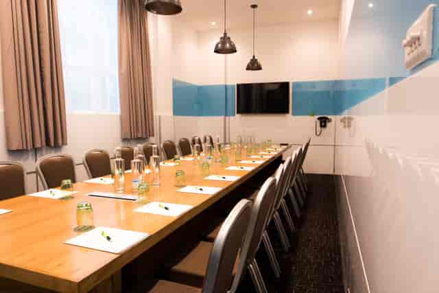 Meeting room at Wesley Euston Hotel, featuring a long wooden table for conferences.