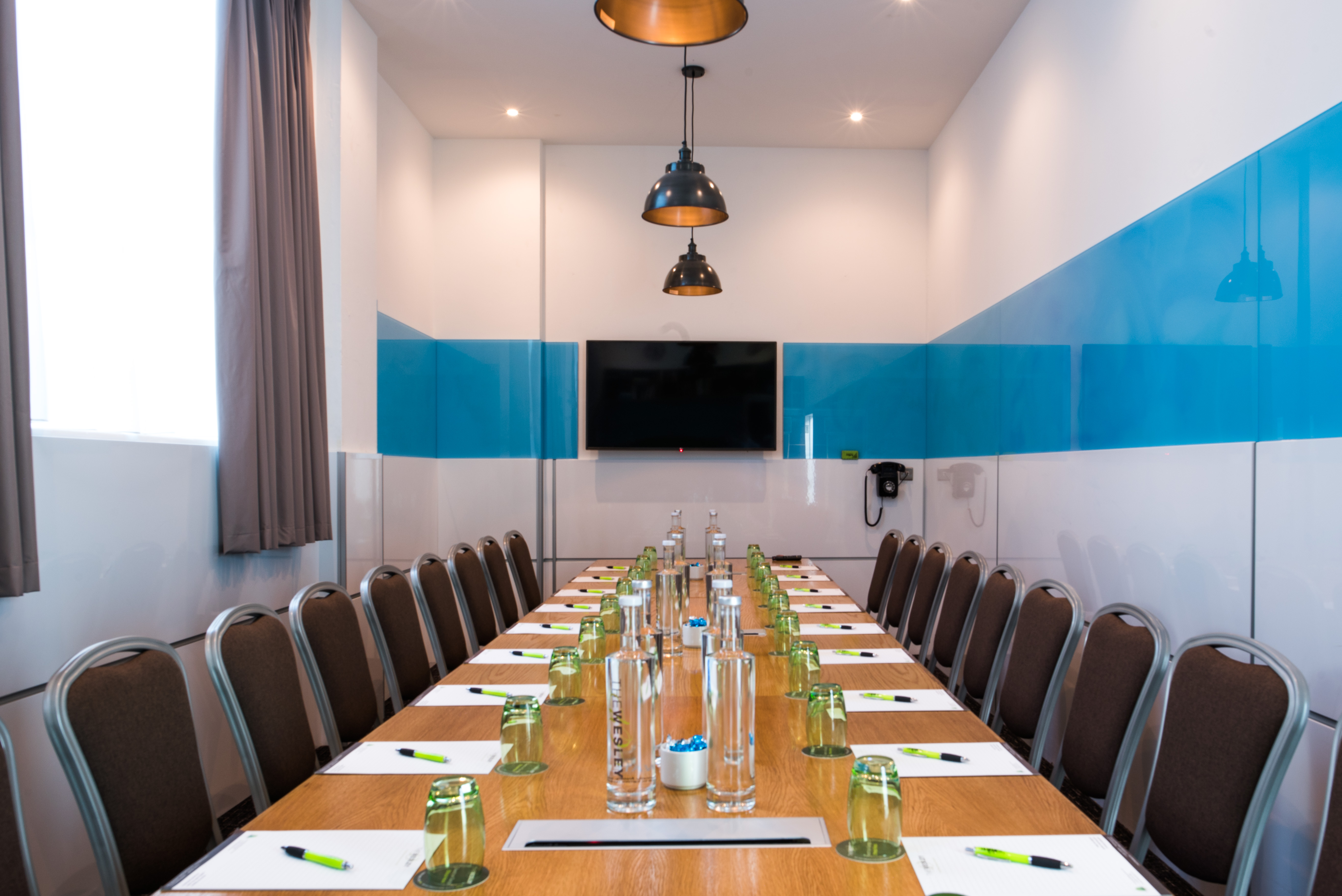 Modern meeting room at Wesley Euston Hotel with long table, ideal for conferences and events. - Banner