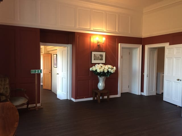 Wren House meeting space with red walls, ideal for intimate gatherings and conferences.