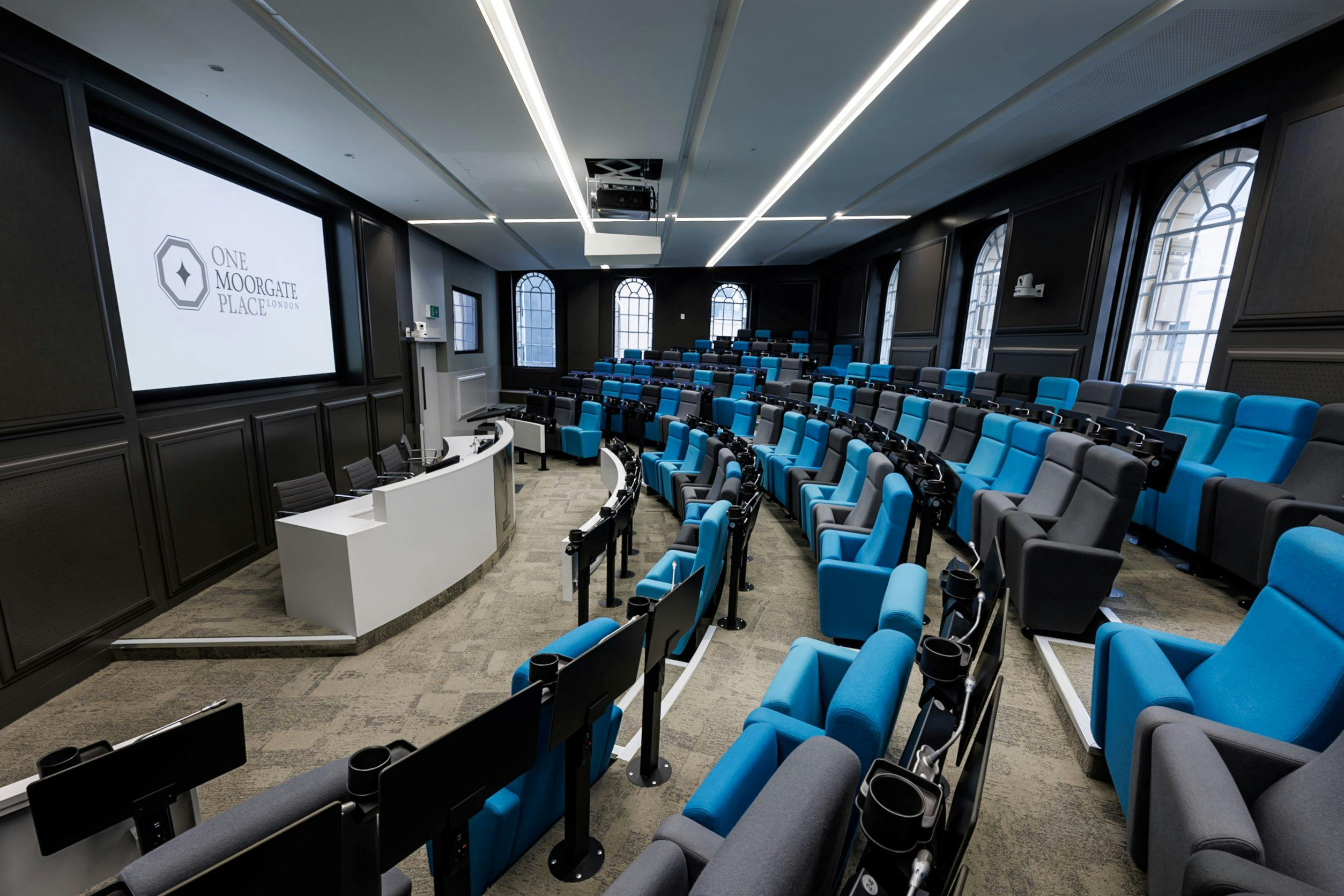 Modern tiered meeting space with blue-gray seating for events at One Moorgate Place.