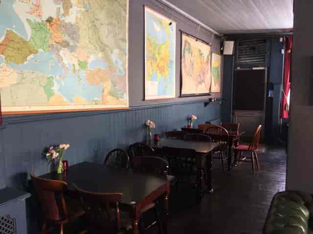 Cozy event space at Whole Pub, ideal for meetings and gatherings with wooden tables.