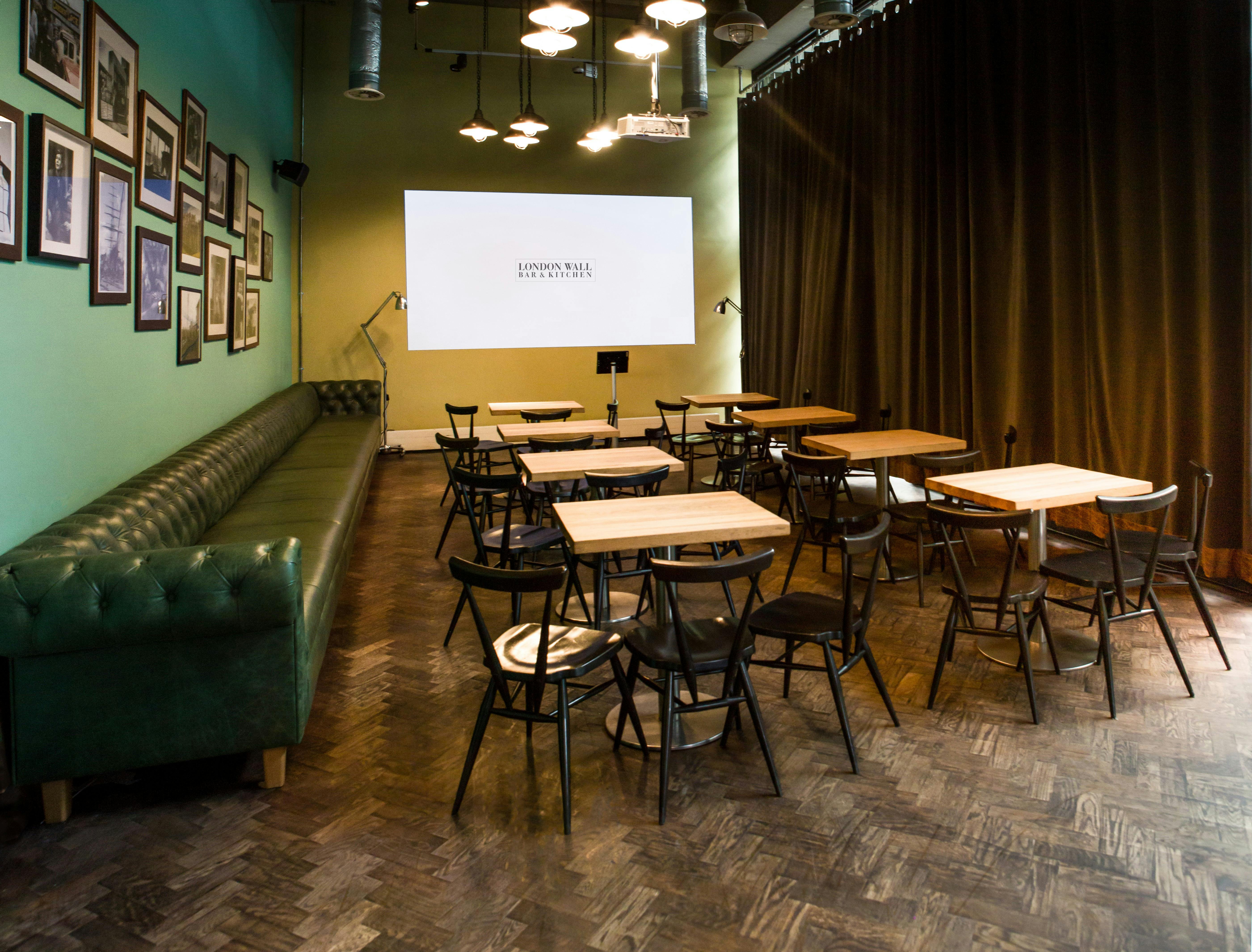 Versatile event space with green walls, ideal for workshops and meetings in London.