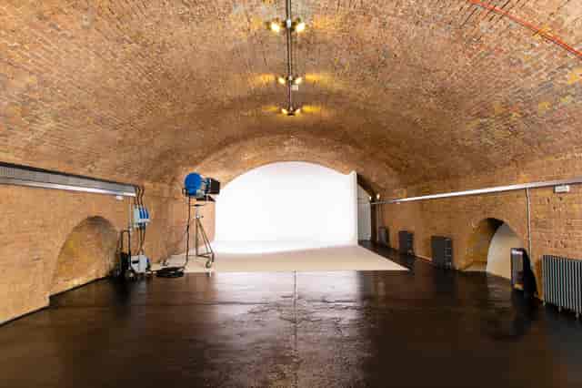 Versatile event space in Rida Haggerston with exposed brick and arched ceiling.