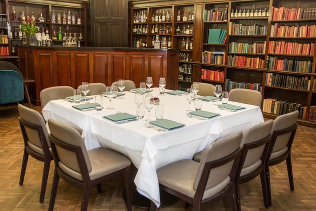 Library Bar at Cinnamon Club: elegant round table for intimate meetings, sophisticated ambiance.