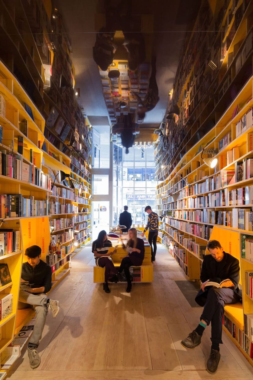 Vibrant bookstore with yellow shelves, perfect for creative events and gatherings.