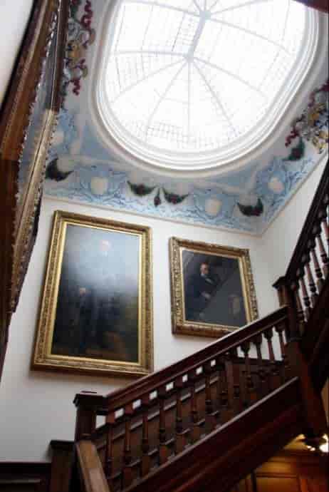 Livery Hall staircase with ornate paintings, ideal for formal events and networking.