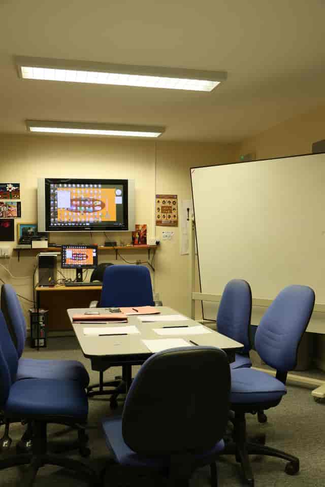 Meeting room with large screen, ideal for seminars and collaborative events.