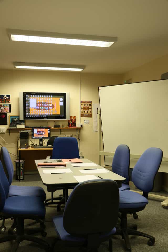 Meeting room with large screen, ideal for seminars and collaborative events.