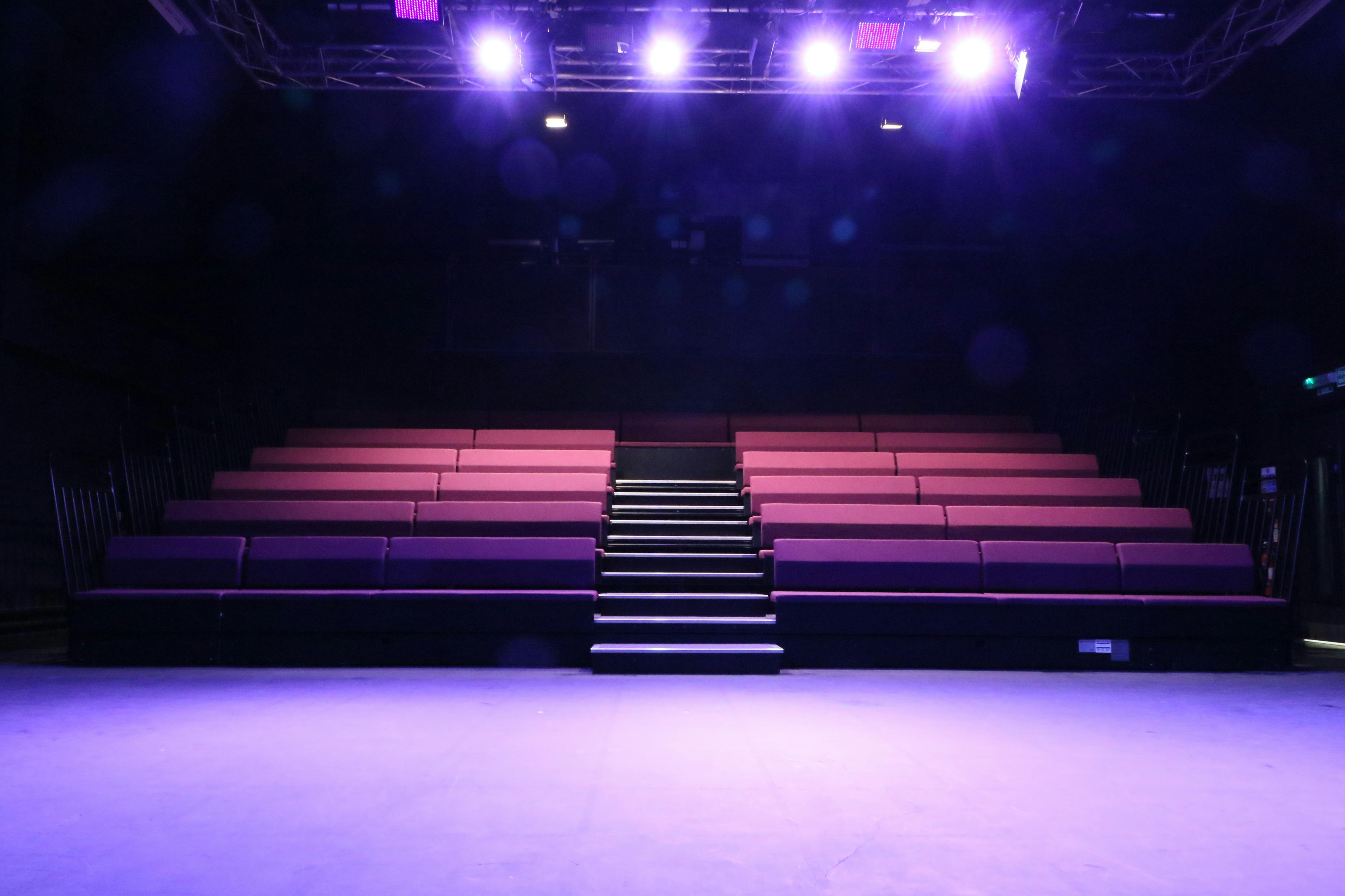 Theatre and conference space with tiered seating for versatile events at Impact Community Arts Centre.