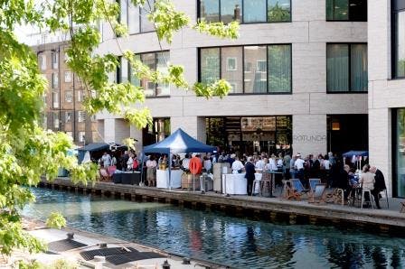 Vibrant outdoor event at Rotunda Bar, featuring tents by the canal for networking.