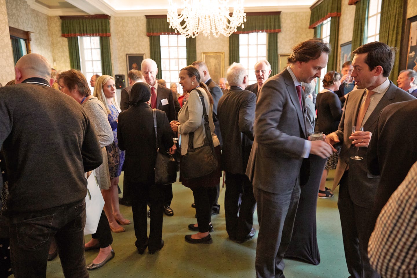 Networking event in Council Room, 170 Queen's Gate; elegant chandelier, professional mingling.