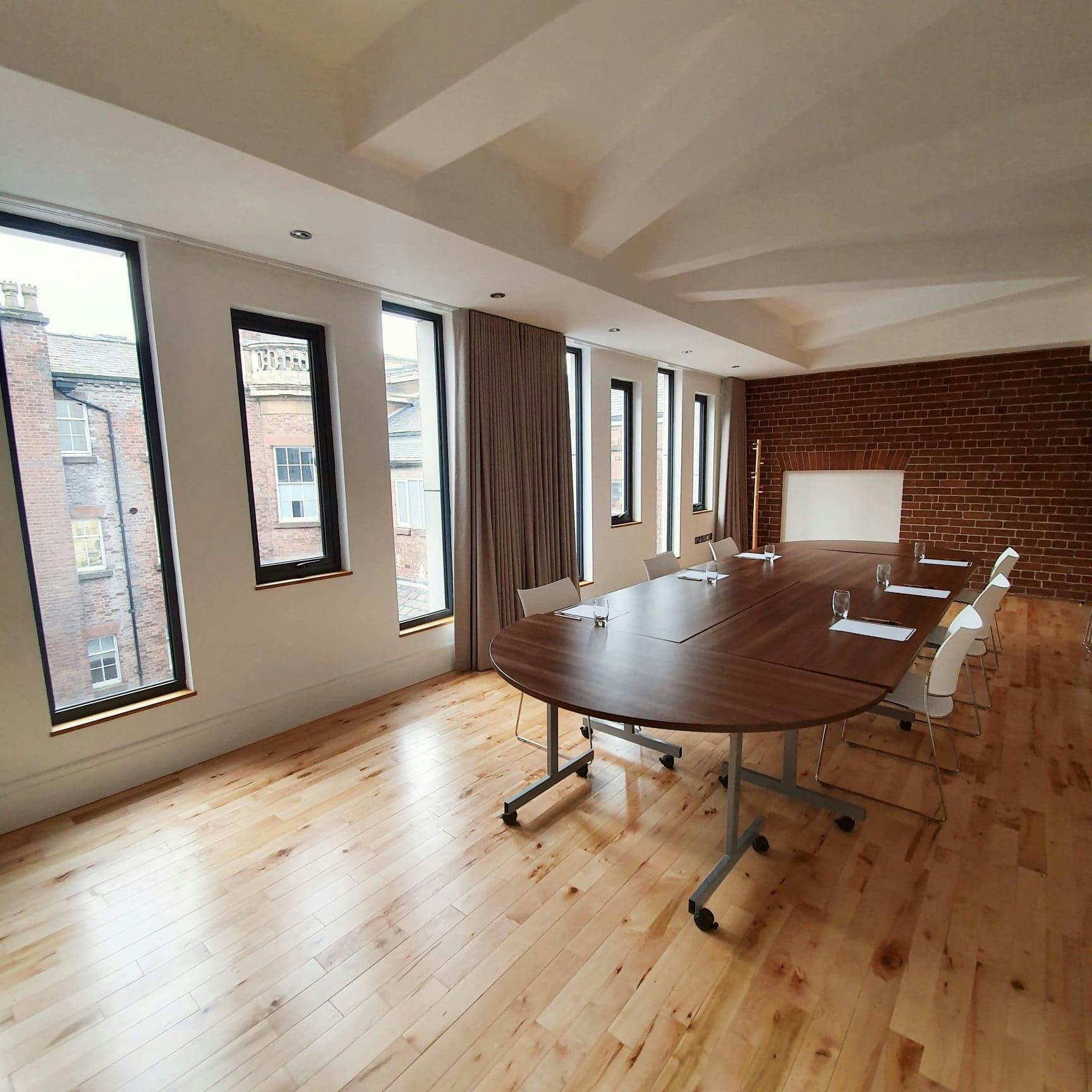 Modern meeting room at Hope Street Hotel with large wooden table and ergonomic chairs.