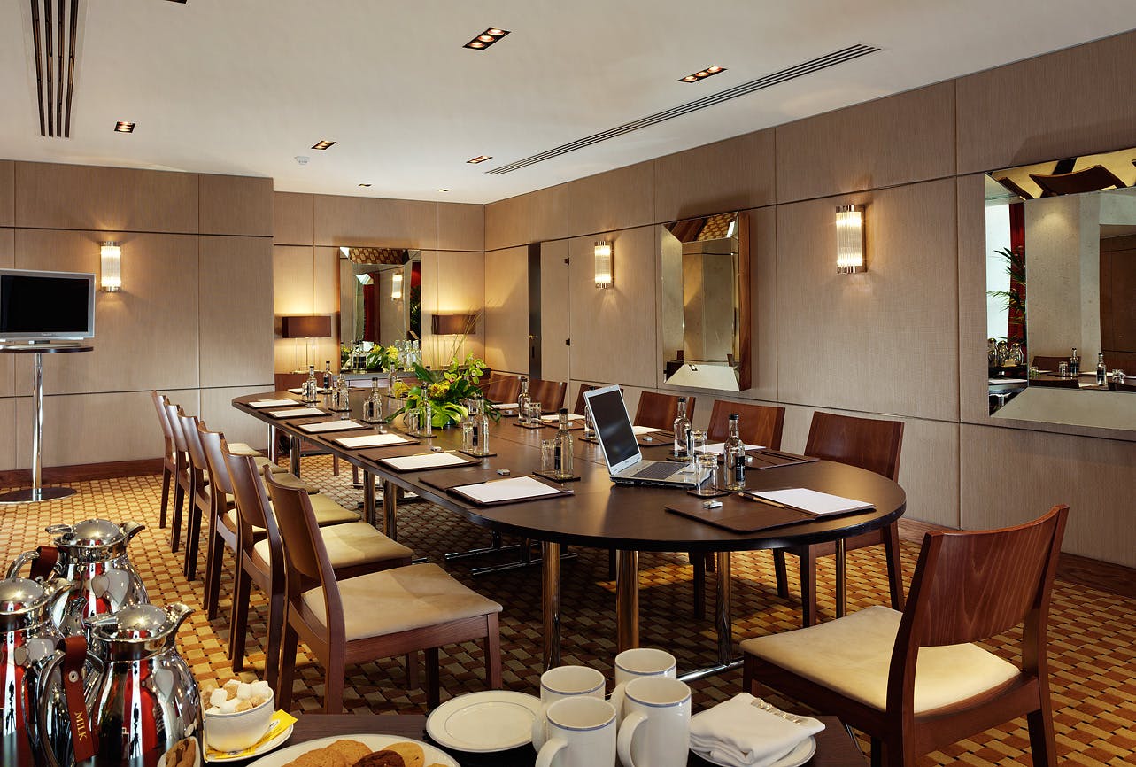 Chestnut Suite meeting room at Royal Lancaster London, featuring an oval table and AV equipment.