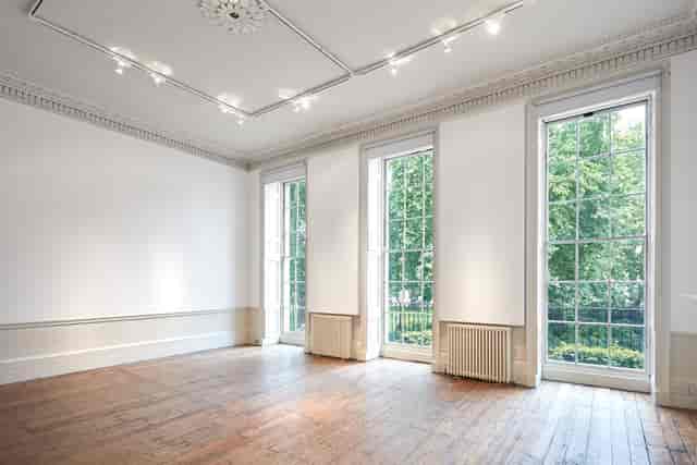 Versatile event space in Fitzroy Square with natural light and hardwood floor for gatherings.