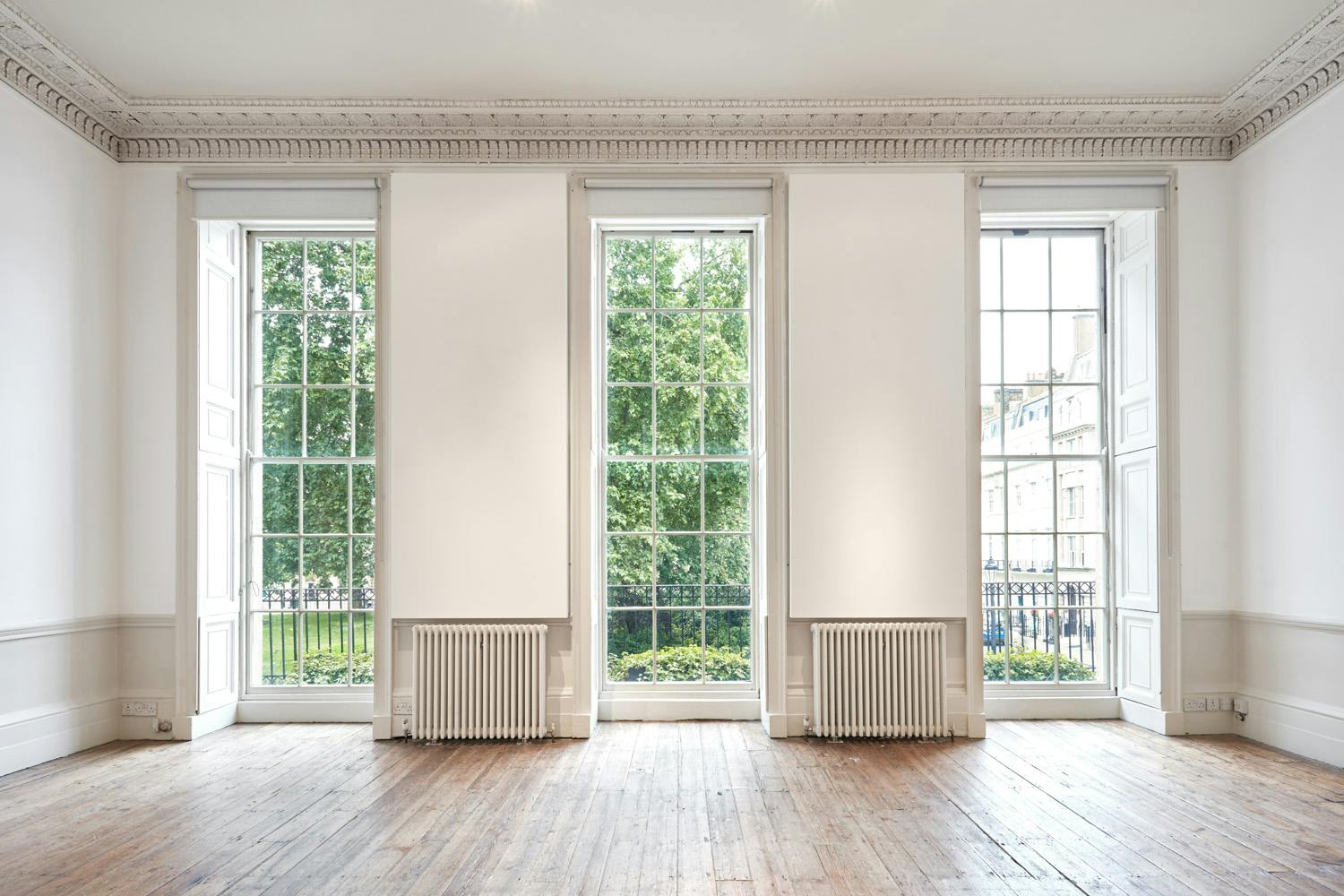 Bright event space in Fitzroy Square House with large windows, perfect for gatherings.