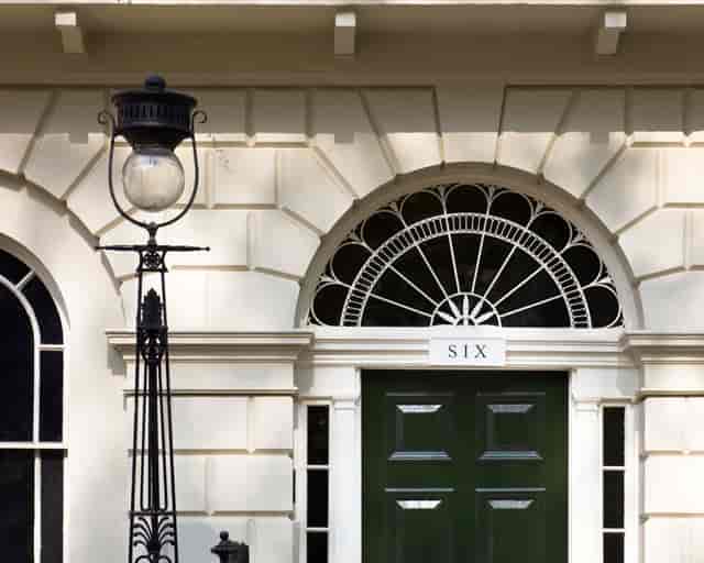 Elegant venue entrance with arched window and green door, perfect for upscale events.