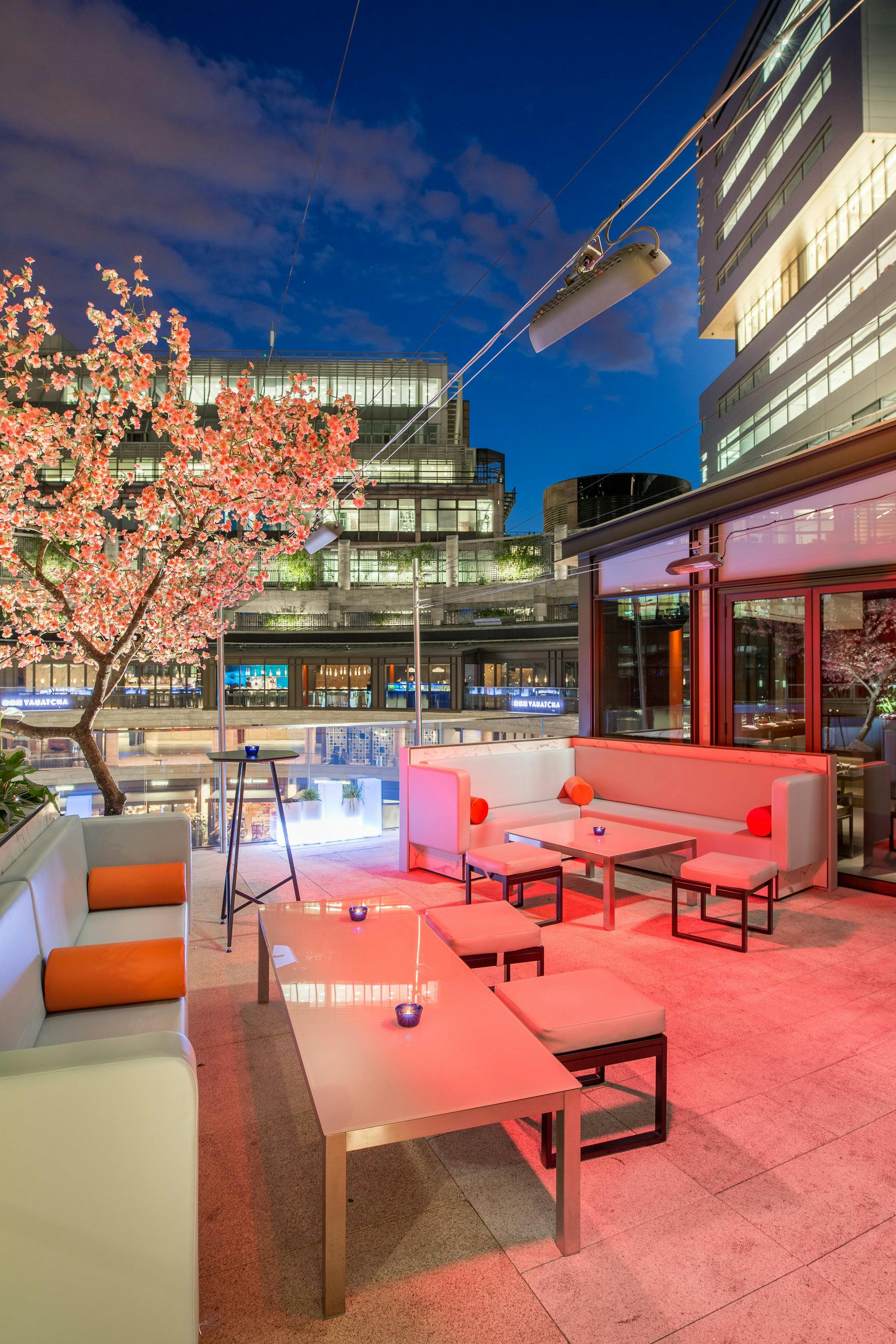 Stylish outdoor event space at Yauatcha City with cherry blossom tree for upscale gatherings.