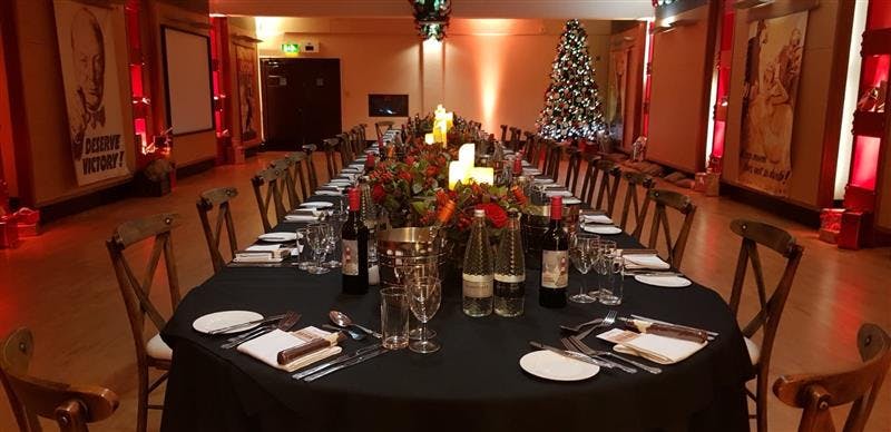 HCA Auditorium banquet table with floral centerpieces for corporate holiday event.