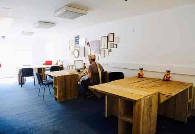 "Versatile desk hire in Blighty Workspace, featuring rustic tables for creative meetings."