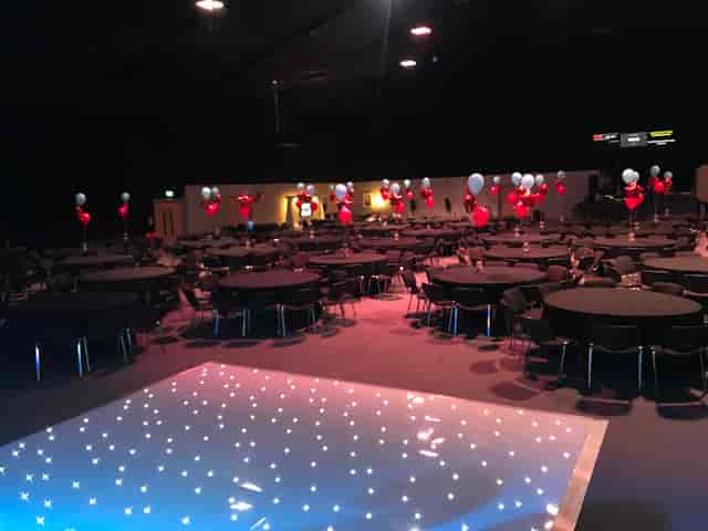 Elegant auditorium with round tables, balloons for corporate events and celebrations.