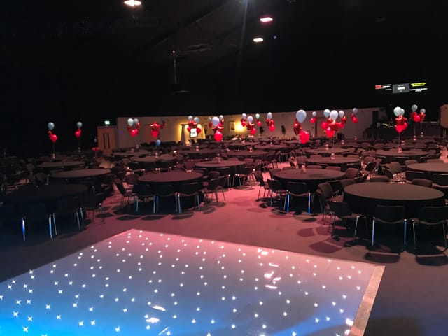 Elegant auditorium with round tables, balloons for corporate events and celebrations.