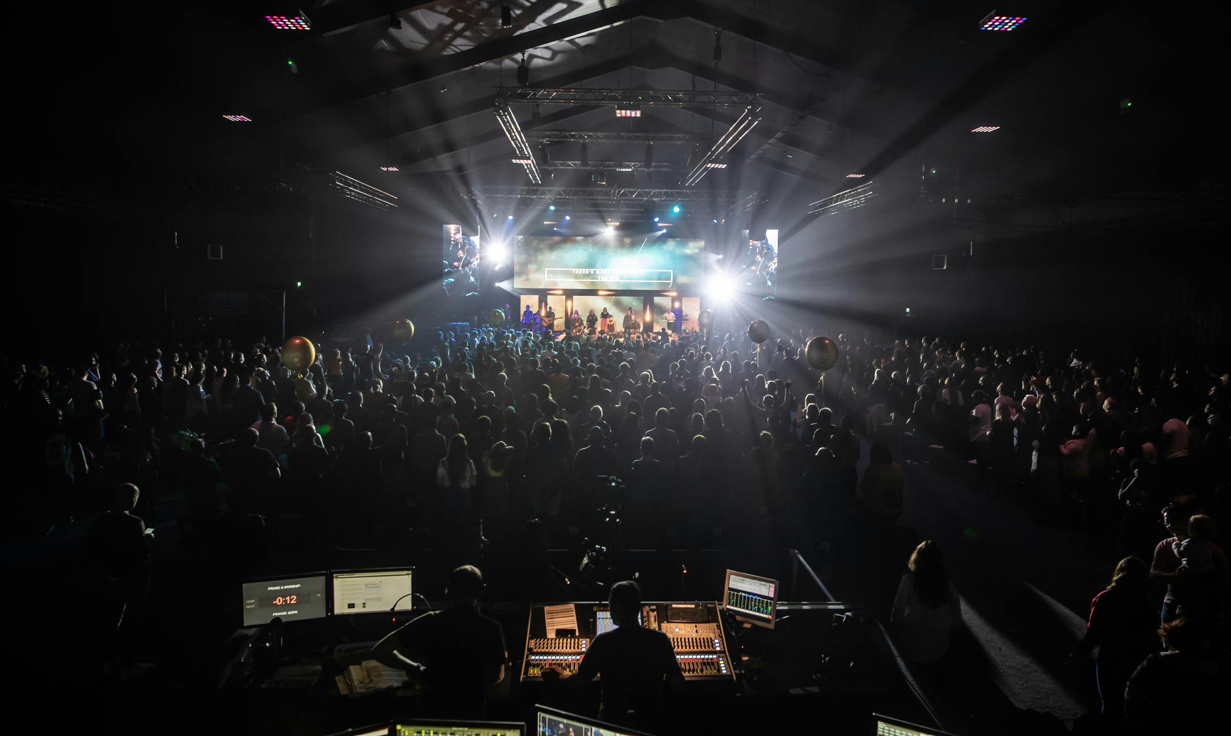 Dynamic auditorium event with engaged audience and vibrant stage lights.