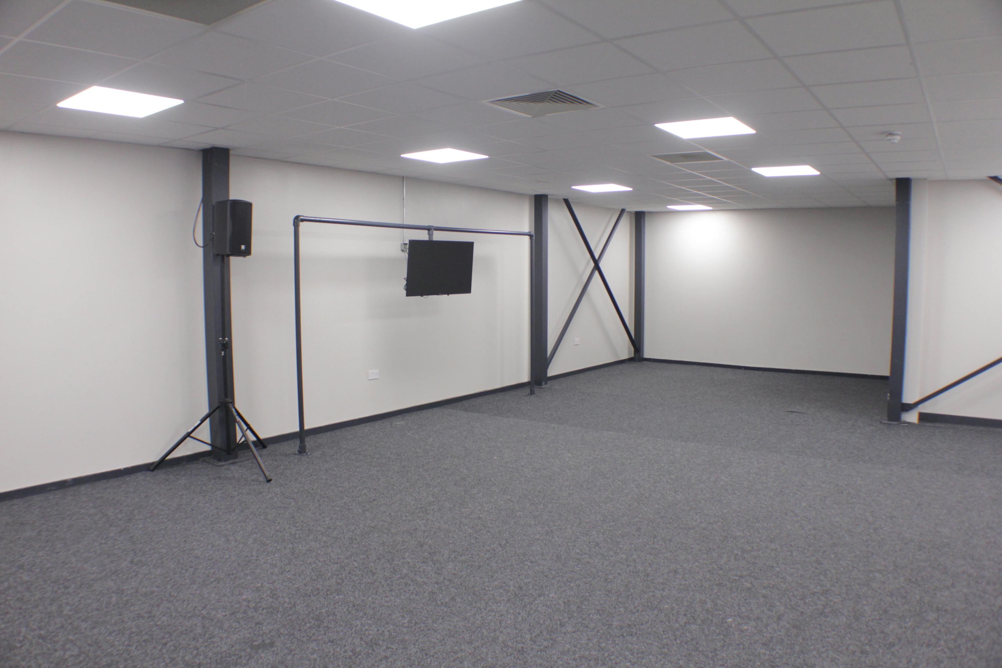 Versatile event space with neutral walls, ideal for meetings and workshops.