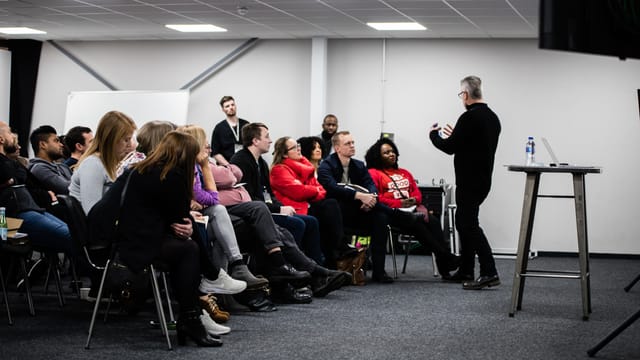 Dynamic audience engaged in a presentation at !Audacious Conferencing event.