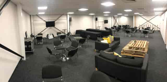 Versatile event space with comfortable seating for networking and presentations.