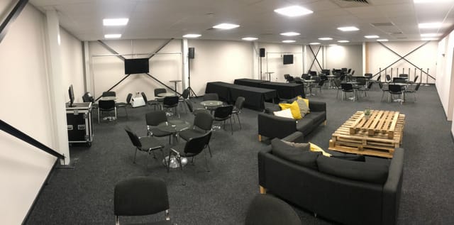 Versatile event space with comfortable seating for networking and presentations.