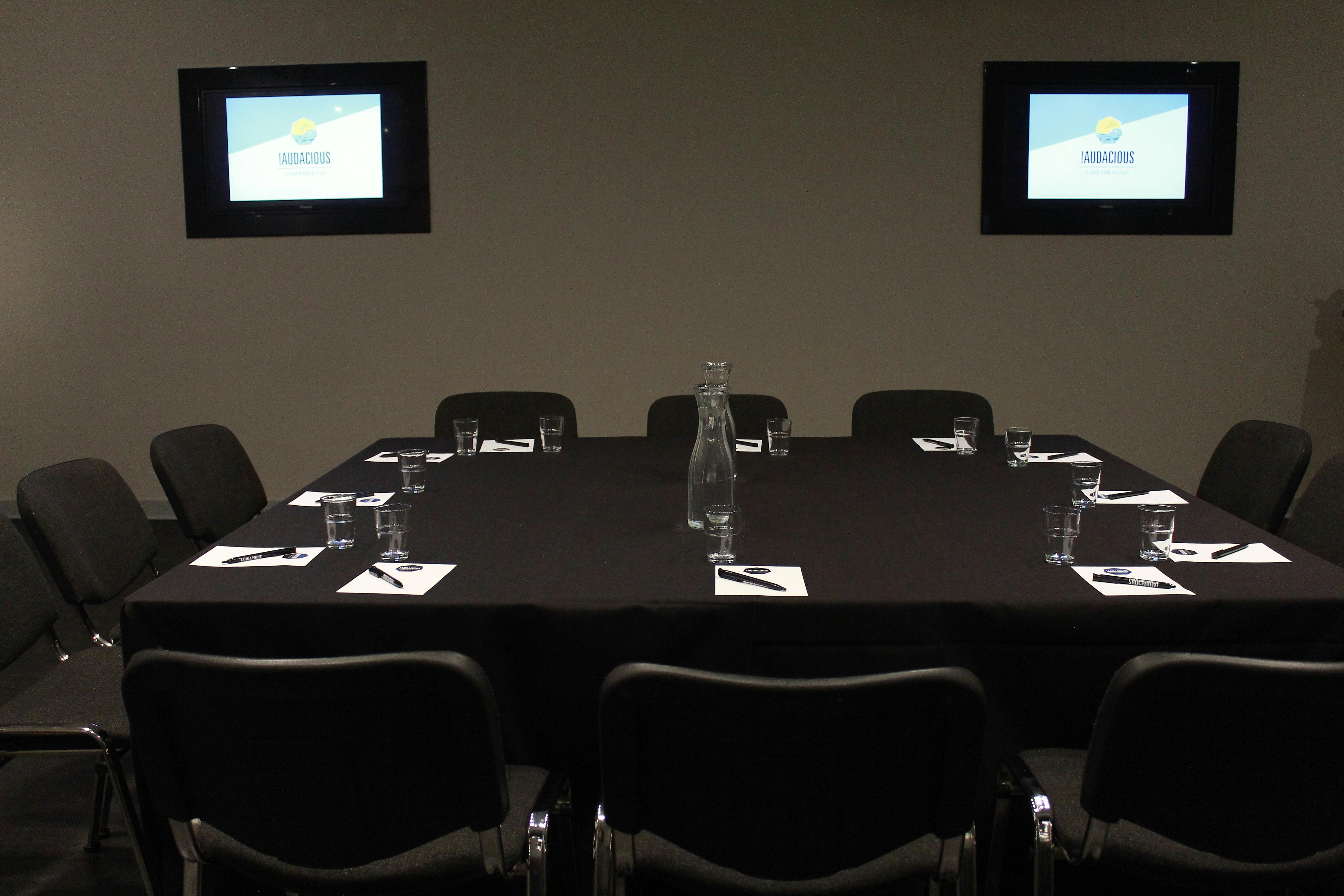 Meeting room with round table setup, ideal for conferences and presentations.