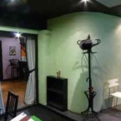 Cozy Fringe Theatre meeting space with green walls, ideal for workshops and gatherings.