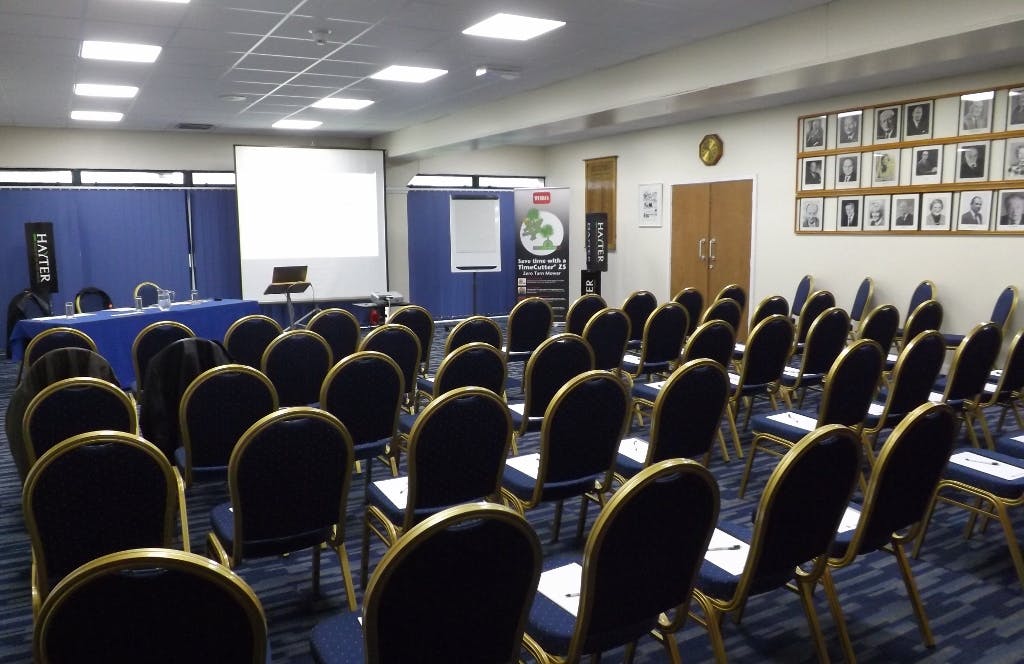 Kleinwort Room setup for presentations with chairs, screen, and flip charts in England.