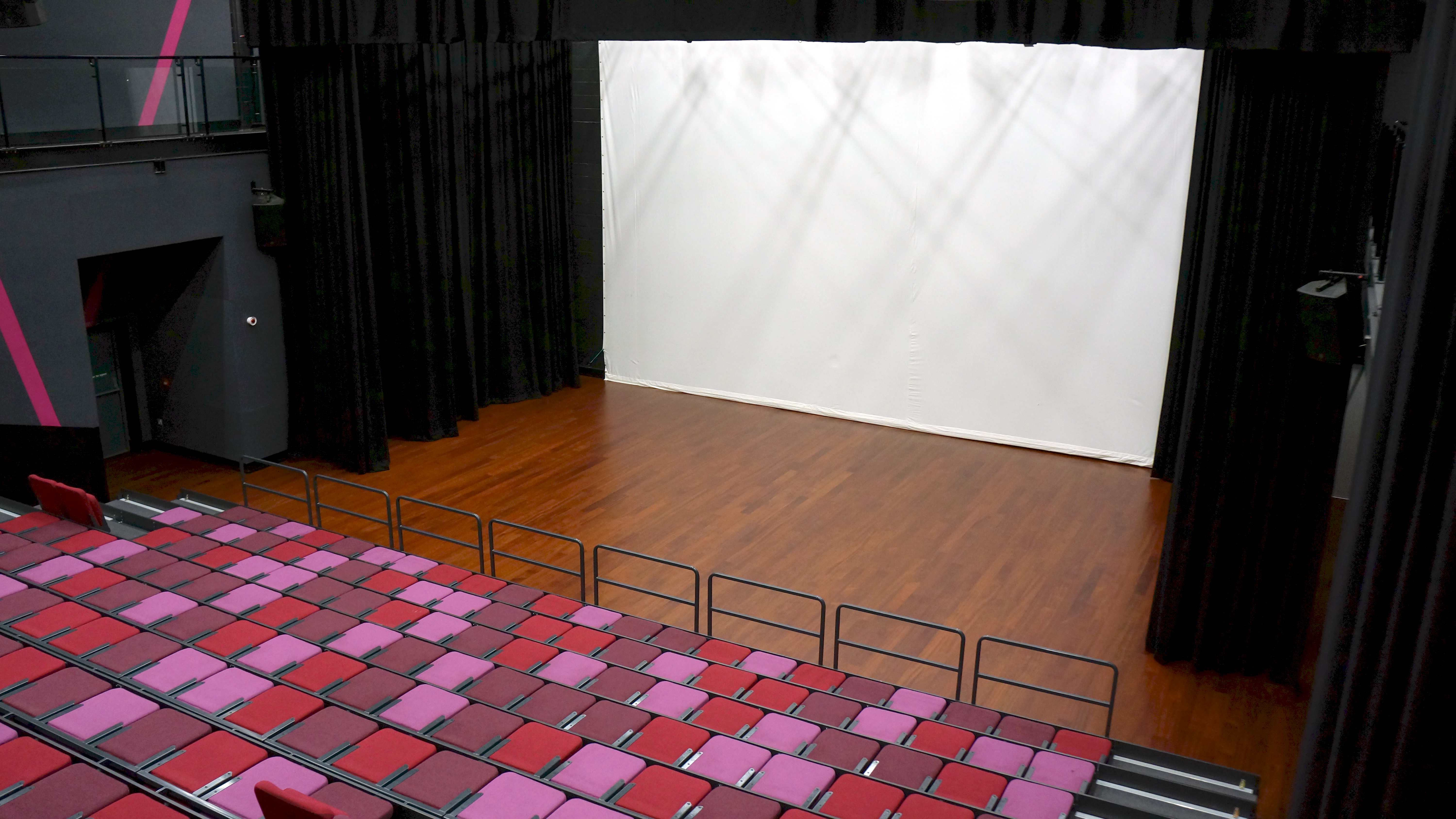 Versatile auditorium with spacious stage and tiered seating for events and performances. - Banner