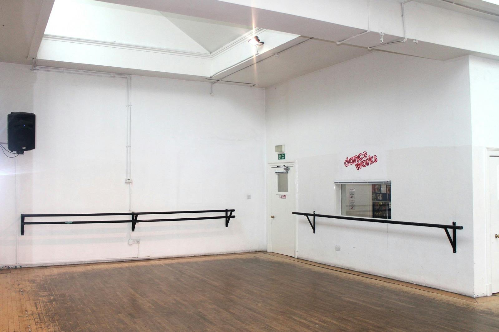 Versatile dance studio with mirrors and ballet bars for workshops and fitness classes.