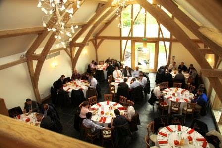 Oak Barn event space with round tables, ideal for corporate gatherings and celebrations.
