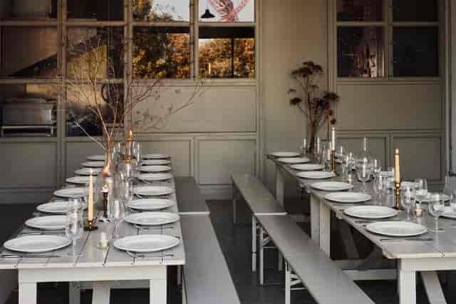 Minimalist autumn event space with communal bench seating for weddings and corporate gatherings.