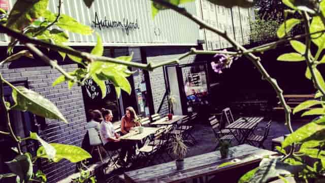 Charming outdoor café venue with greenery, perfect for informal meetings and networking events.