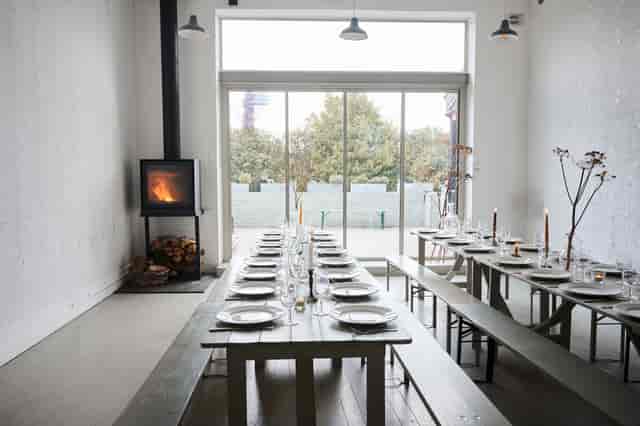 Minimalist banquet event space with fireplace for corporate dinners and private celebrations.