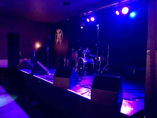Stage setup for a live concert in Nambucca with blue lighting and drum kit.