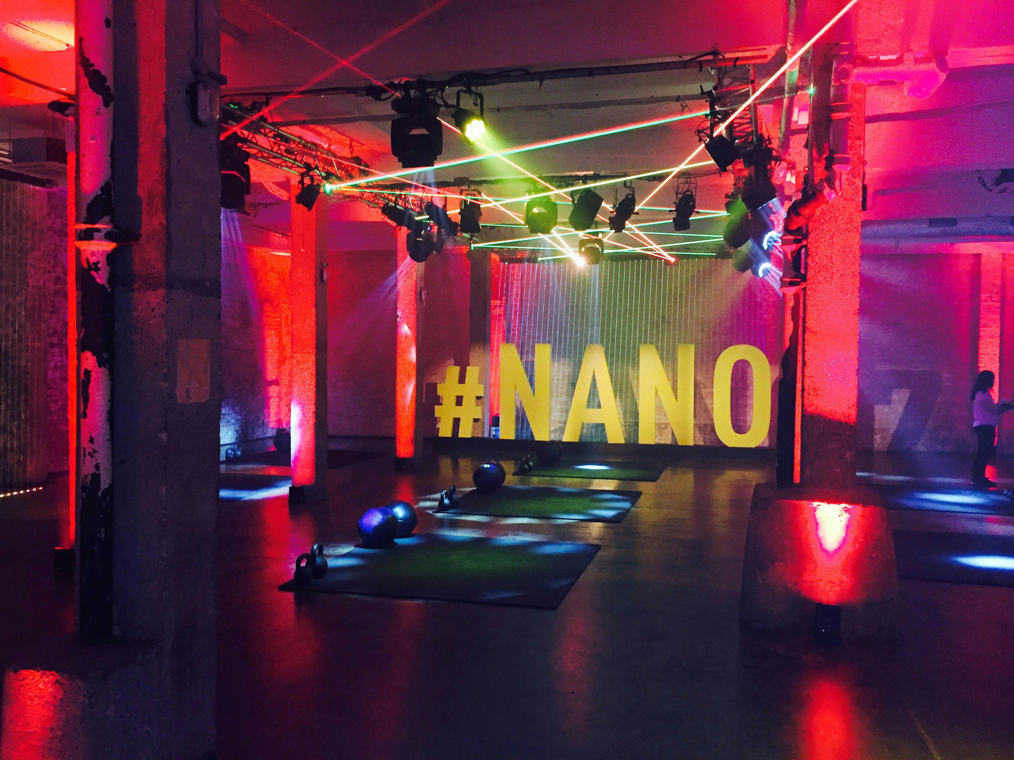 Vibrant event space with bold lighting and "#NANO" sign for wellness-themed gatherings.