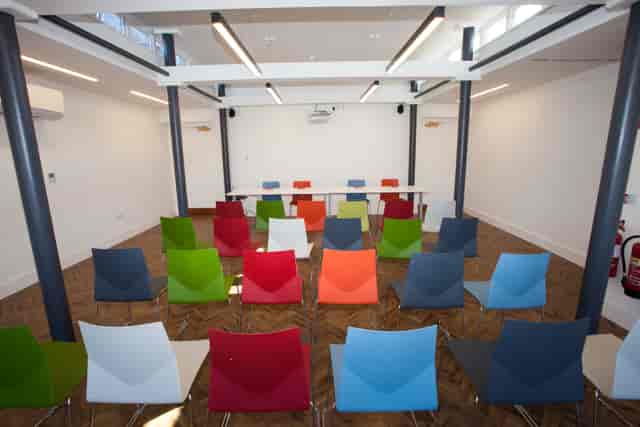 The Studio at Headspace Manchester: Theater-style workshop space with vibrant chairs.