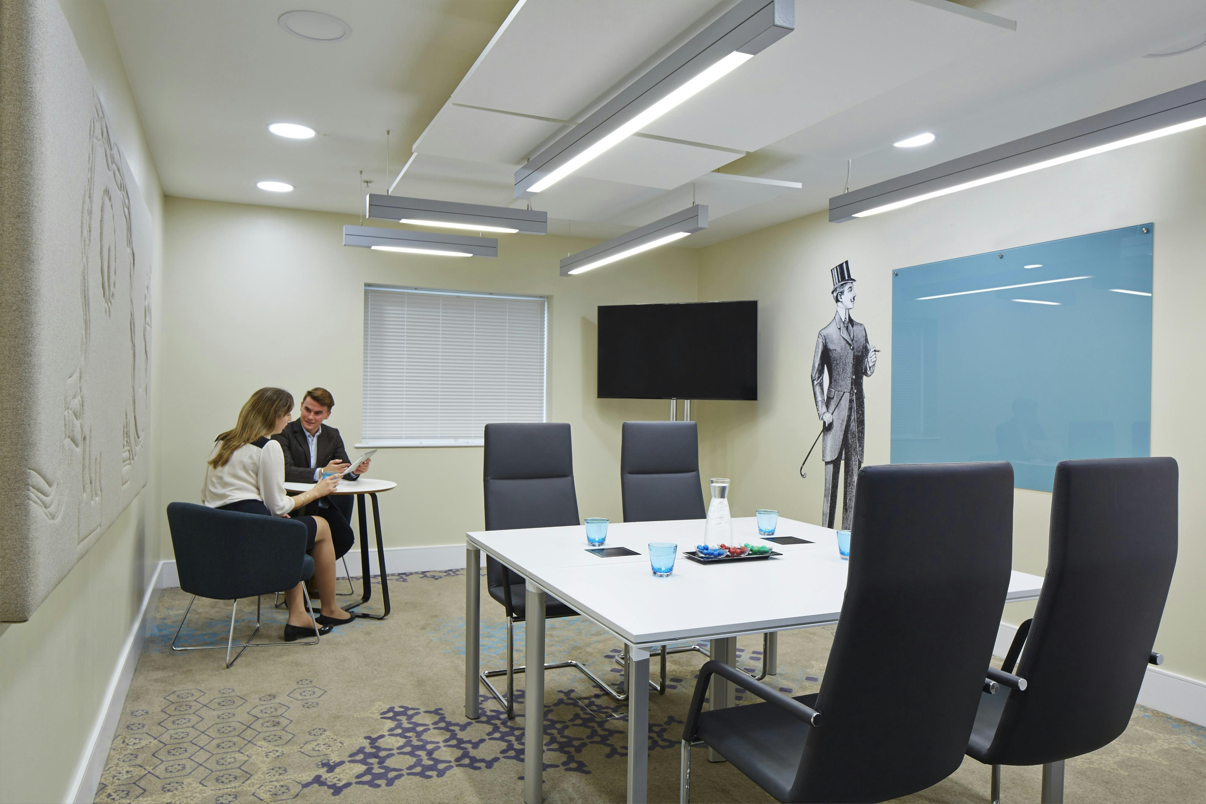 Modern meeting room in London Marriott Kensington, featuring sleek table and natural light.