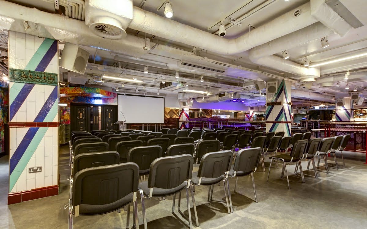 Versatile conference space with black chairs and vibrant decor for presentations in Shoreditch.