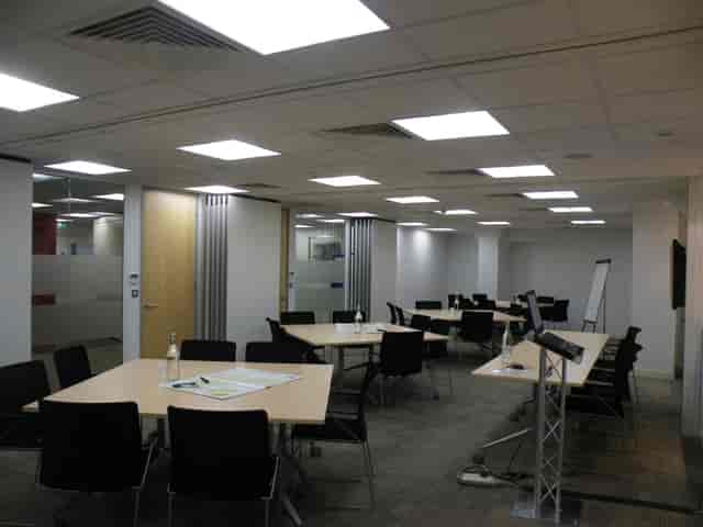 Flexible workshop meeting room with movable tables & whiteboards.