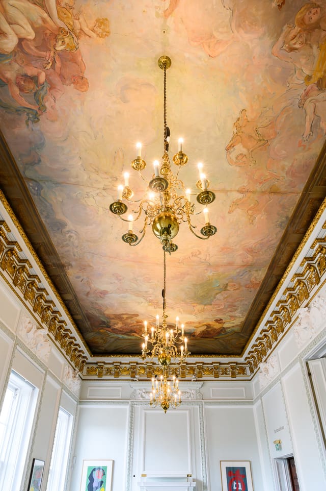 Opulent Barnard Room ceiling with chandelier, ideal for weddings and galas.