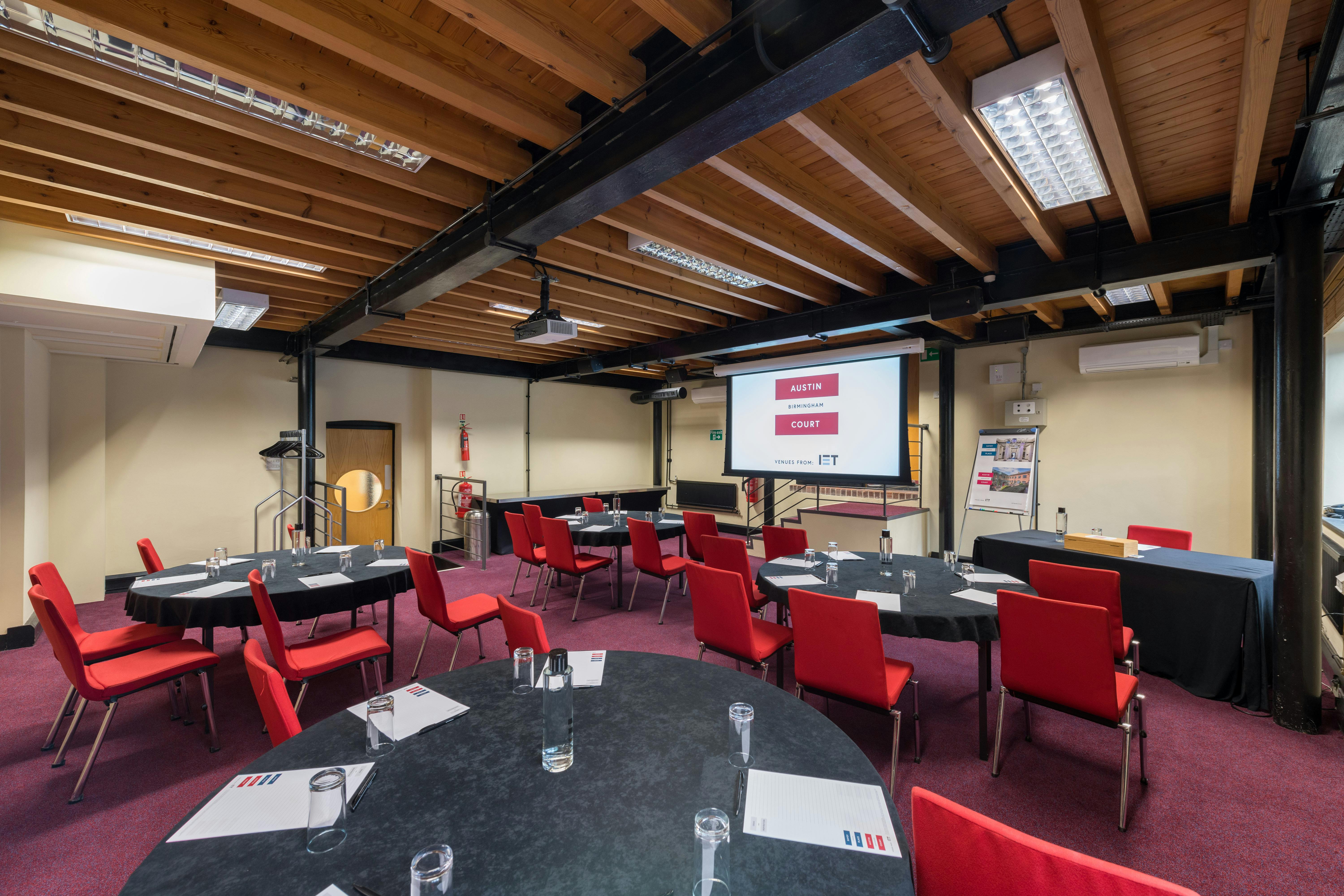 Boulton Room at IET Birmingham: modern meeting space with round tables for corporate events.