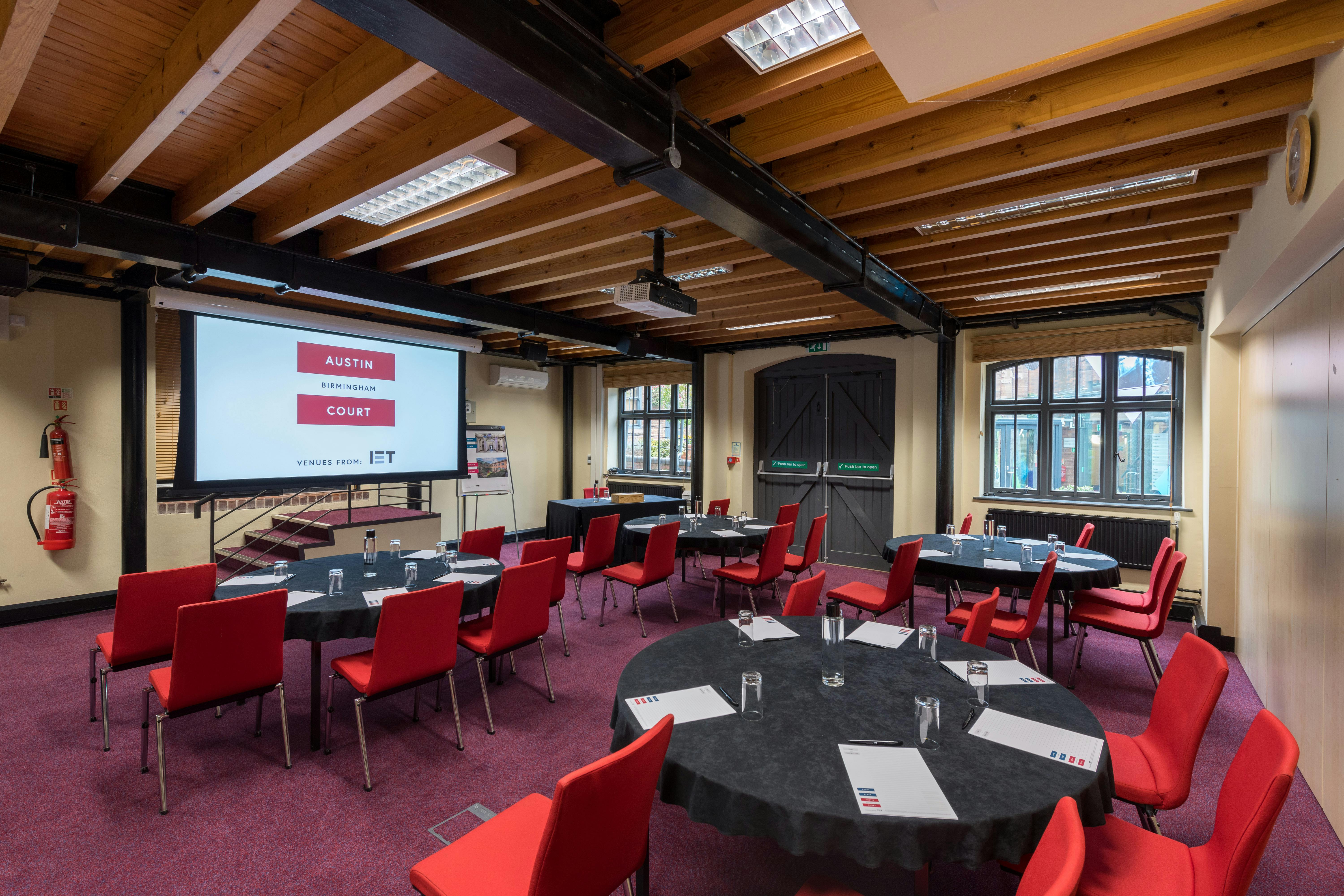 Boulton Room at IET Birmingham: Austin Court, featuring round tables and a large screen.