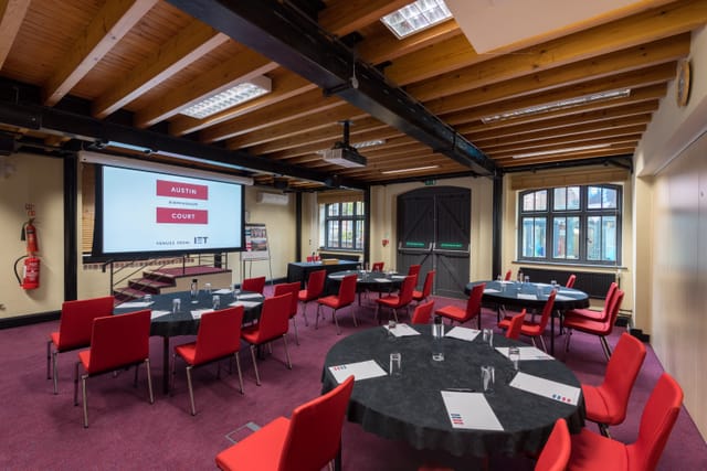 Boulton Room at IET Birmingham: Austin Court, featuring round tables and a large screen.