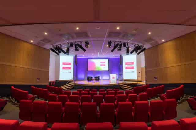 Kingston Theatre at IET Birmingham with dual screens and vibrant purple lighting for conferences.